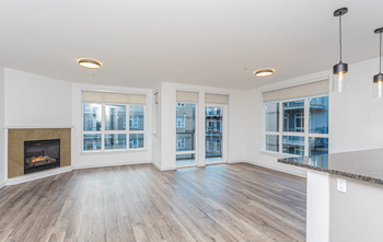 A spacious living room with a fireplace and large windows.